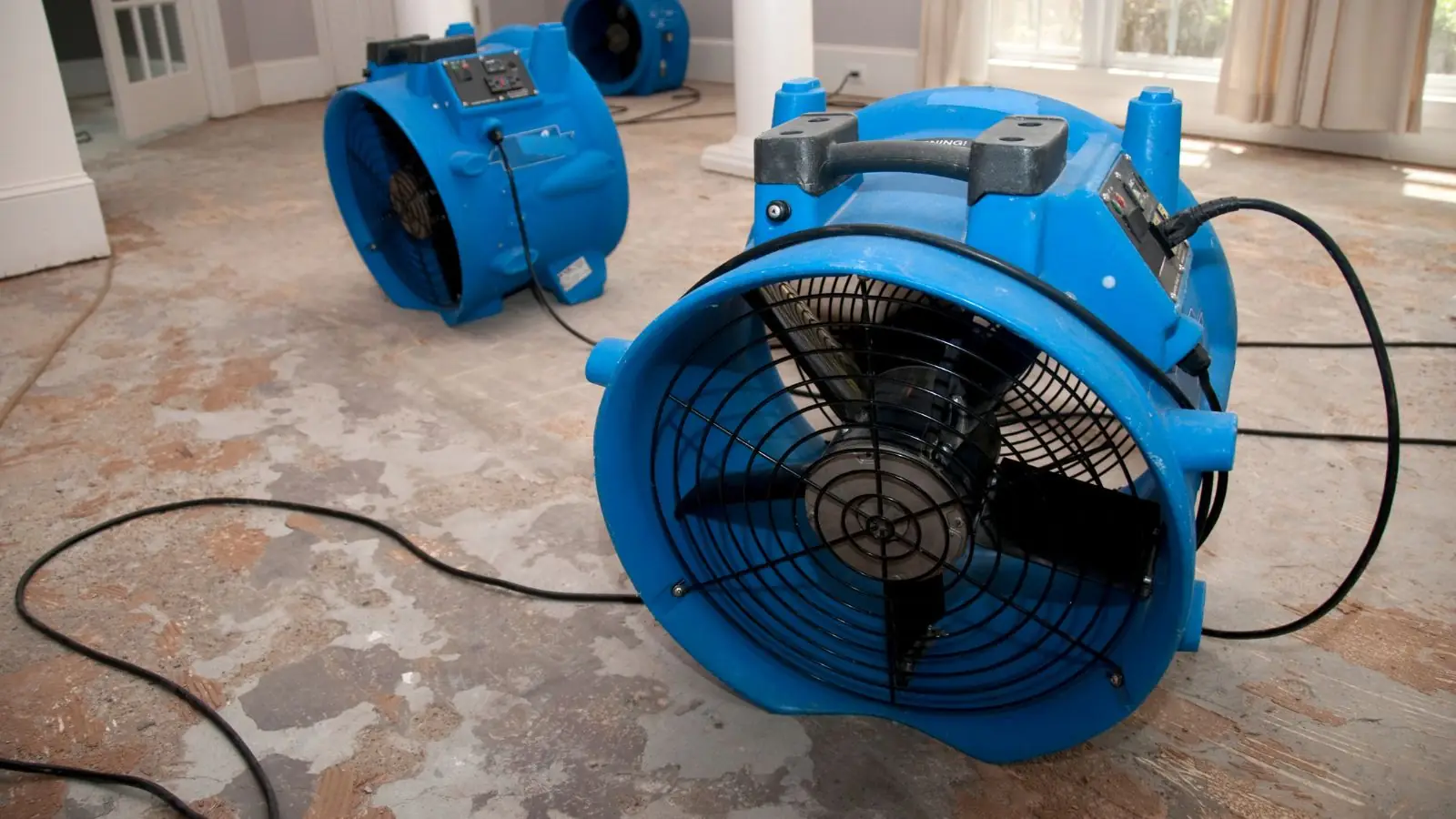 Blue air mover drying a water-damaged floor